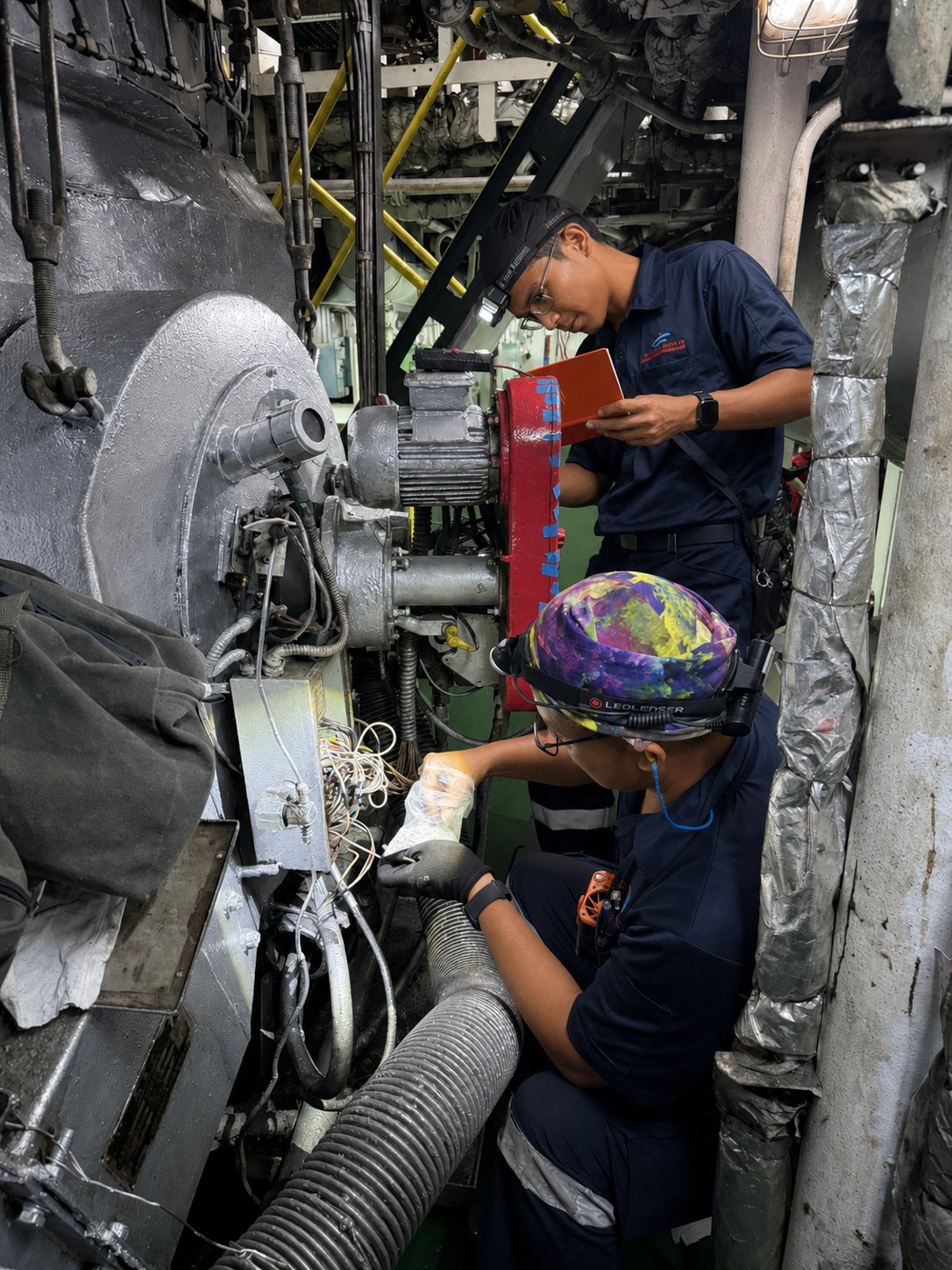YMA technicians repairing motor wiring in a vessel engine room